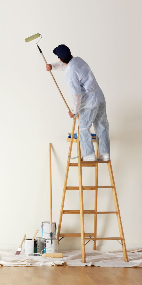 Professional Painting Services Provider On Ladder Using Paint Roller