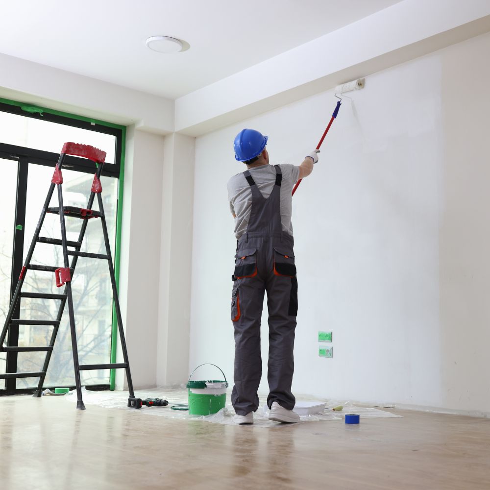 Professional Painting Services Provider Applying Paint To Commercial Building Wall